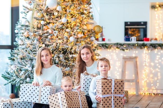 Blije kinderen bij de kerstboom met de cadeautjes