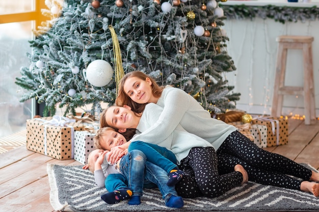 Blije kinderen bij de kerstboom met de cadeautjes