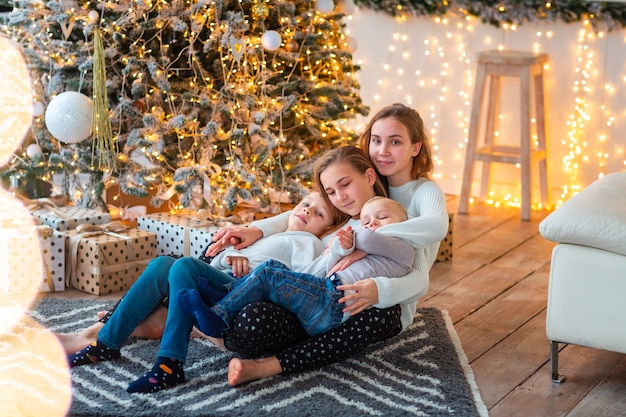 Blije kinderen bij de kerstboom met de cadeautjes