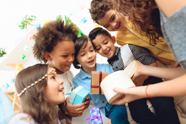 Blije kinderen kijkt in geschenkverpakking gehouden door feestvarken.