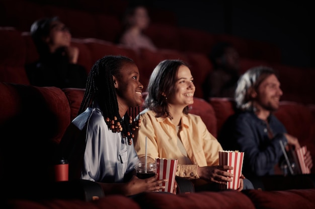 Blije meiden die genieten van het kijken naar de film