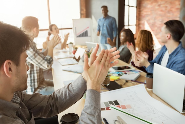 Blije partners klappen in de handen van collega die presentatie maakt over winstverhoging, kopieer ruimte