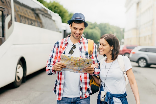 Blije toeristen of reizigers die met blije uitdrukking op de kaart kijken, blij zijn om nog een plek te zien om te bereiken, een goed humeur hebben na een prachtige busreis, bezienswaardigheden bezoeken, samen reizen