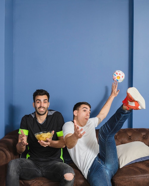 Blije voetbalfans in de woonkamer