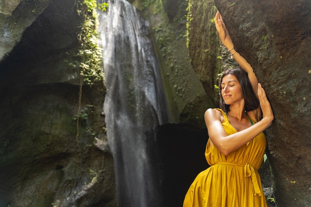 Blijf lachen. Mooie brunette meisje geniet van haar stop in de buurt van waterval, met excursie in de wilde natuur