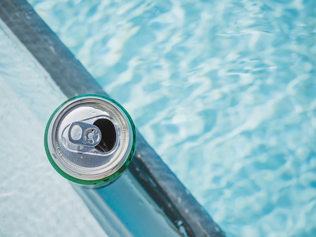 Blikje bier op de achtergrond van het zwembad