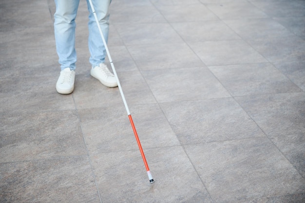 Blind man closeup with a walking stick Walking down the street