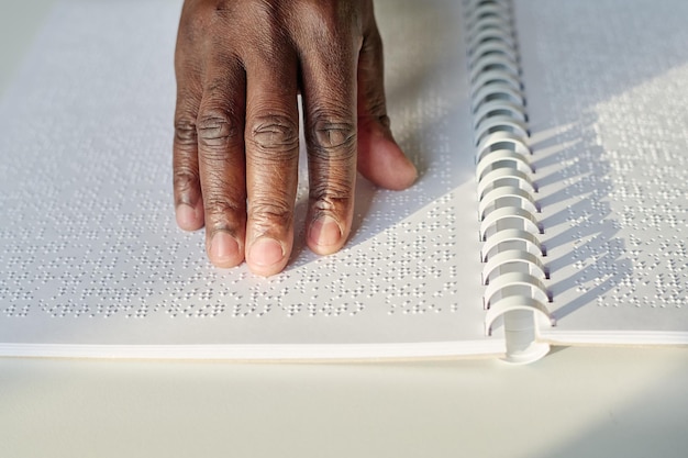 Blind man reading book at table