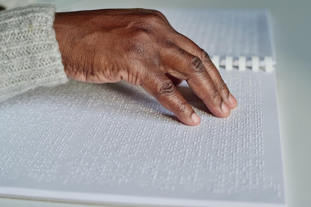 Photo blind man reading with his hand