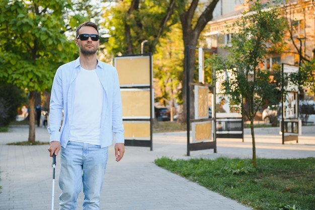 Foto cieco uomo ipovedente con bastone da passeggio