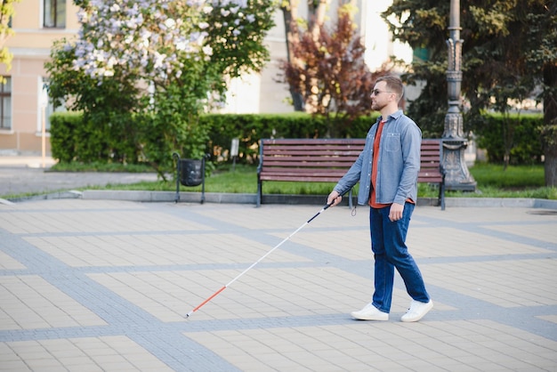 Blind Man Walking On Sidewalk Holding Stick