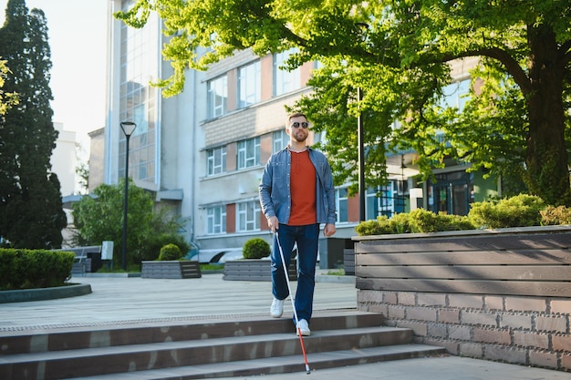 Blind Man Walking On Sidewalk Holding Stick