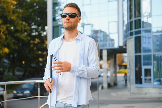 Blind Man Walking On Sidewalk Holding Stick