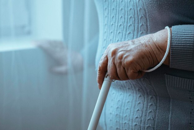 Photo blind person holding white cane