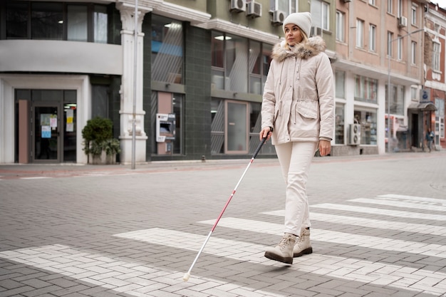 blind person walking through the city with blind stick
