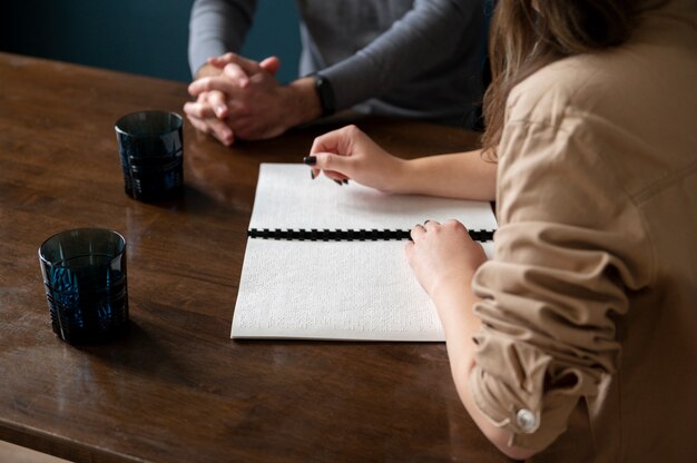 Photo blind woman reading  to a man using the braille language