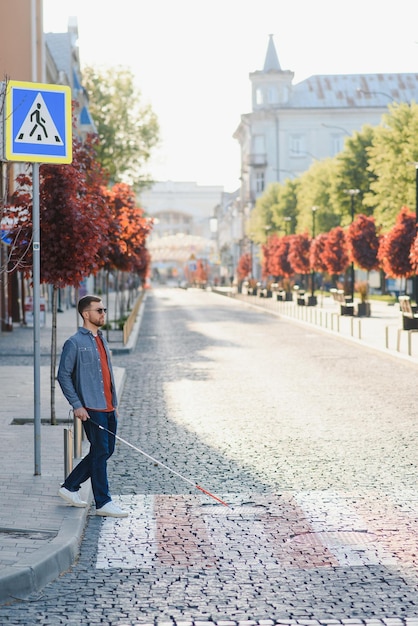 Blind young man crossing road