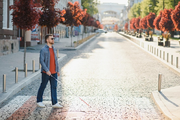 Blind young man crossing road