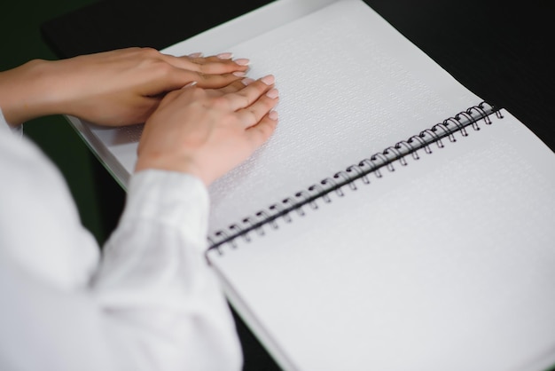 Blinde vrouw leest boek geschreven in braille Close-up vingeraanraking naar braille Code