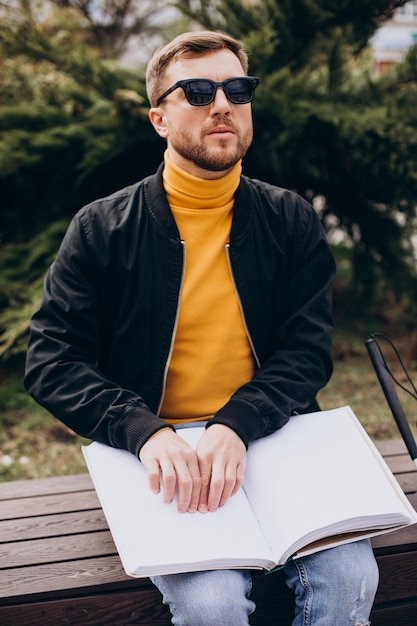 Blinded man reading by touching braille book