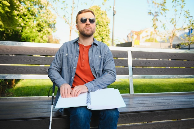 Foto uomo accecato che legge toccando il libro braille