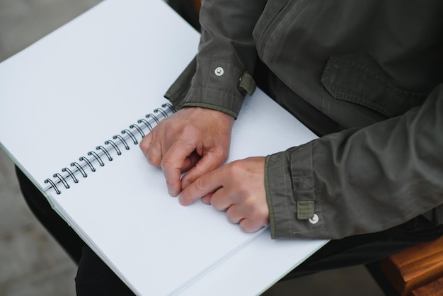 Blinded man reading by touching braille book