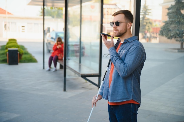 Blinded man waiting for bus at a bus station