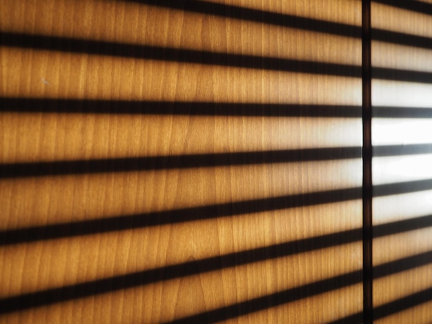 Blinds shadow on wooden wall background