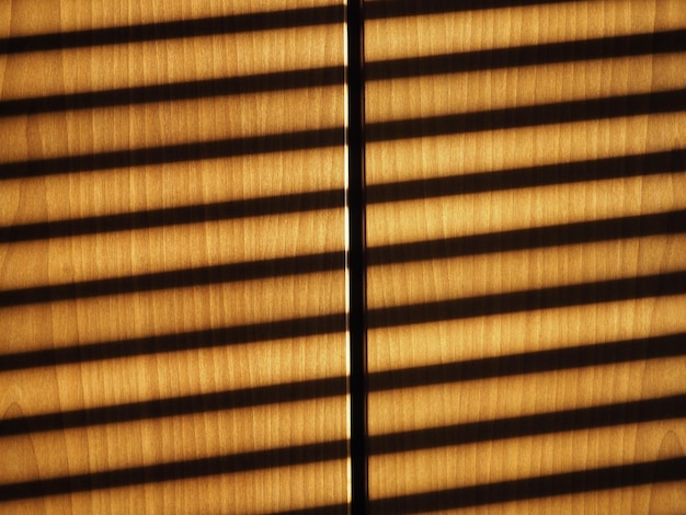 Blinds shadow on wooden wall background