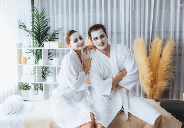 blissful couple in bathrobe with facial cream mask quiescent