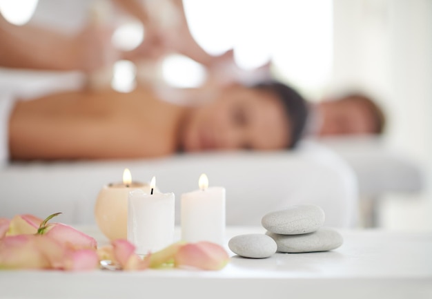 Beato relax una coppia sposata che riceve massaggi in una spa con candele in primo piano