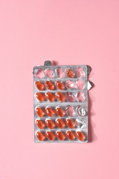 Blister of gelatin pills on pink background