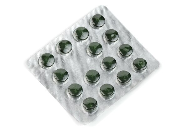 Blister pack of green spirulina pills isolated on white background