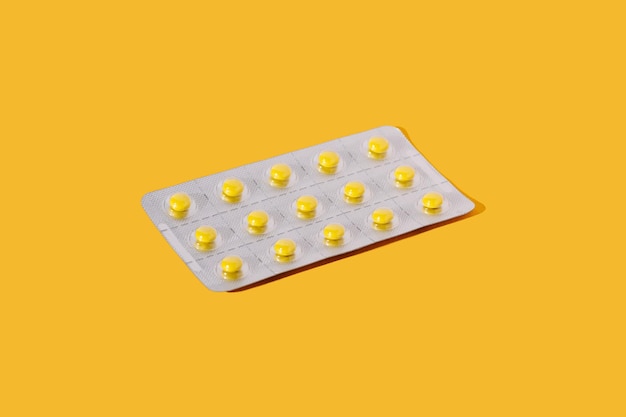 Blister pack with pills on a yellow background