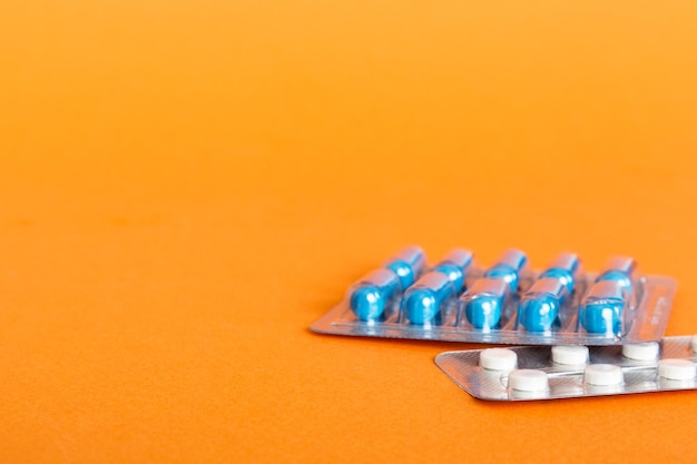 Блистерная упаковка с витамином на цветном фоне Таблетки для лекарств на светлом фоне Лекарства и таблетки по рецепту плоские лежали фон синие медицинские таблетки в блистере