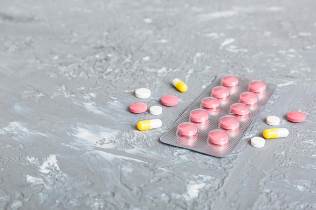 Confezione blister con vitamina su sfondo colorato pillole medicinali su sfondo chiaro medicinali e pillole da prescrizione sfondo piatto compresse rosa in blister
