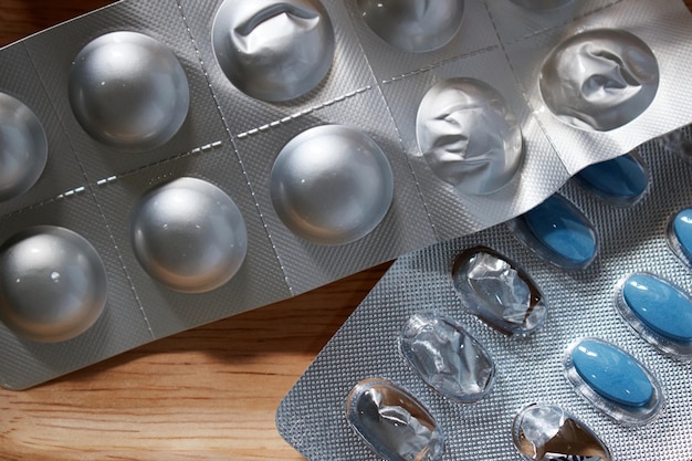 A blister of pills and a blister of ice on a table.