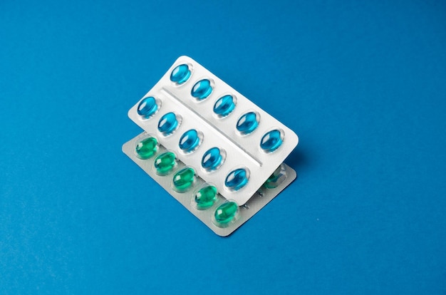 Blisters Transparante kleur capsules verpakking Pillen pijnstillende verpakking pijnstillers kalmerende pillen verpakking Rood groen blauw medicijngel capsules op witte achtergrond