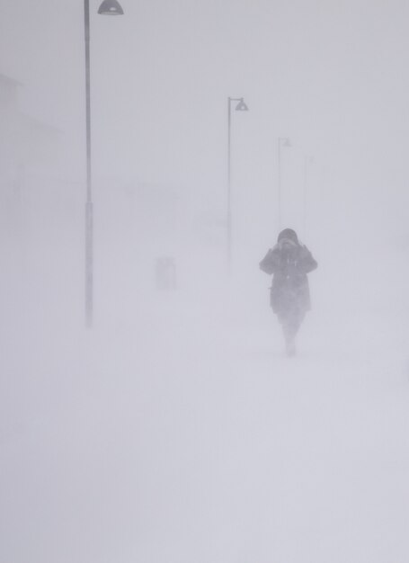 사진 longyearbyen, 눈에 걷는 여자에 블리자드. 추상 모호한 겨울 날씨 배경