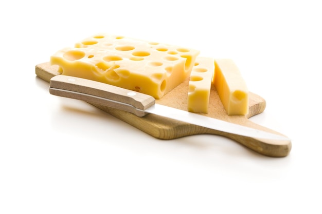 白い背景で隔離のまな板の上のおいしいチーズのブロック