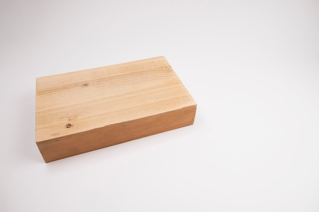 A block of wood lies on a white background. The choice of wood for furniture