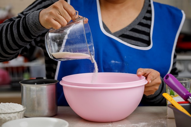 Bloem toevoegen aan een kom om een bananenpannenkoek te maken Thuisbakconcept