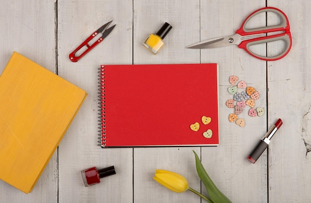 Bloem tulp blanco rood notitieblok geel boek schaar nagellak lippenstift en knoppen