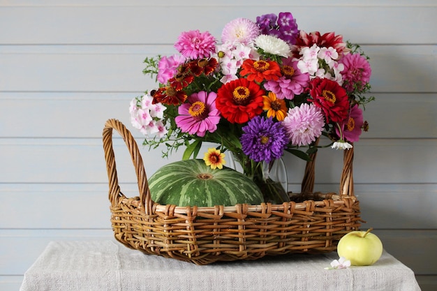 Foto bloemen en een pompoen in een mand op de tafel huisje nog steeds leven zomer tuin oogst