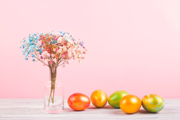 Bloemen en gekleurde eieren op de tafel.