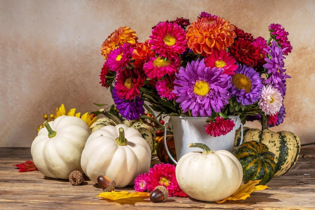 Bloemen en pompoenen op houten tafel achtergrond Boeket van kleurrijke chrysant pioenrozen met witte decoratie pompoenen herfst dankzegging vakantie achtergrond kopie ruimte