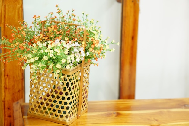 Bloemen in de mand worden op tafel in de coffeeshop geplaatst