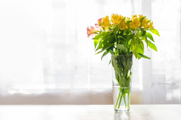 Bloemen in een glazen vaas op tafel