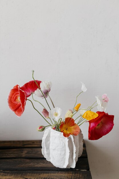 Bloemen in een moderne vaas rustiek stilleven prachtige rode en gele papaver op een oude houten bank Zomer wilde bloemen bloemen behang ruimte voor tekst