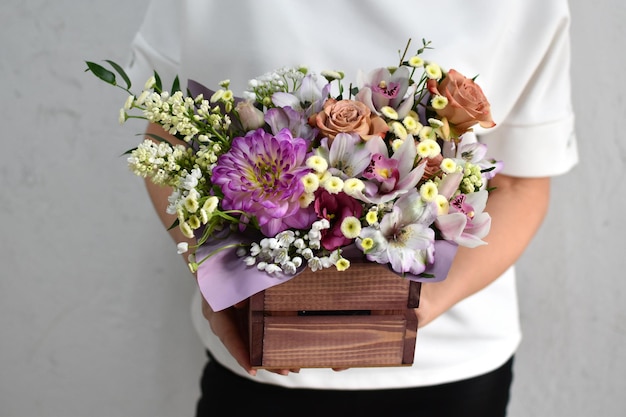 Bloemen in hoedendoos vrouw met een boeket bloemen online catalogus van bloemenbezorgwinkel plantensamenstelling